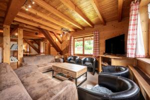 a living room with a couch and chairs and a tv at Les Chalets de la Revue in Flumet