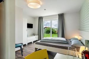 a bedroom with a bed and a window and a table at Kleine Auszeit in Thalheim