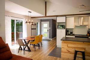 a kitchen and dining room with a table and yellow chairs at Chalet Victoria - Private Spa & Nature in Pont-Rouge