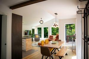 a dining room and living room with a table and chairs at Chalet Victoria - Private Spa & Nature in Pont-Rouge