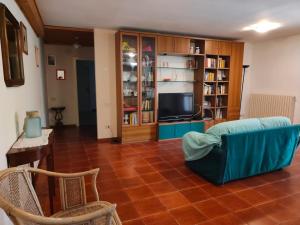 a living room with a blue couch and a television at Villa Vittorio a 4km dal mare in Trebbiantico