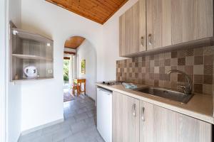 a kitchen with wooden cabinets and a sink at Maltas studios in Corfu
