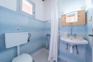 a blue bathroom with a toilet and a sink at Maltas studios in Corfu