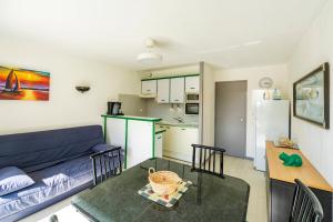 a living room with a blue couch and a table at Evasion Atlantique, accès plage in Capbreton