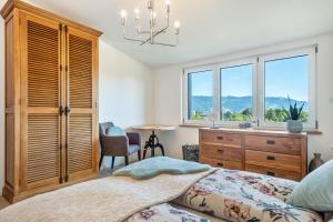 a bedroom with a bed and a dresser and windows at Pfänderblick in Lindau