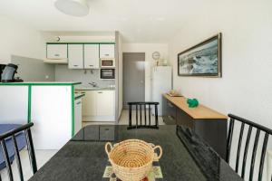 a kitchen and dining room with a table and a kitchen sidx sidx sidx at Evasion Atlantique, accès plage in Capbreton +19 photos