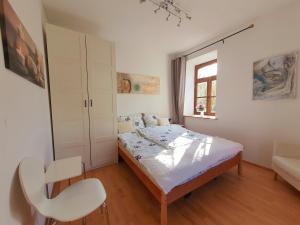 a bedroom with a bed and a chair in it at Schöne Wohnung Landhaus-Flair in Aachen