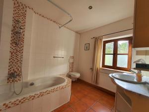 a bathroom with a tub and a toilet and a sink at Schöne Wohnung Landhaus-Flair in Aachen +7 photos