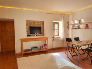 a living room with a table and a television on a wall at Schöne Wohnung Landhaus-Flair in Aachen