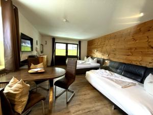 a room with a bed and a table and a couch at Zirbenstüberl - Chiemgau Karte in Inzell