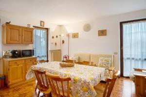 a kitchen with a dining room table with a tablecloth on it at Appartamento Eva in Folgaria
