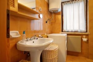 a bathroom with a sink and a toilet and a window at Appartamento Eva in Folgaria +16 photos