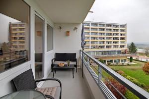 a balcony with a chair and a table and a building at Ferienwohnung Alpensicht in Oberteuringen