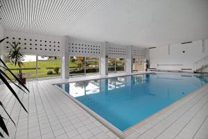 a swimming pool in a house with windows at Ferienwohnung Alpensicht in Oberteuringen