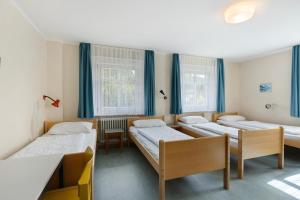 a room with four beds and a table at Ferienheim Eisenbach in Eisenbach +27 photos