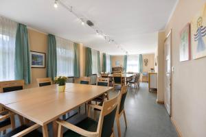 a dining room with tables and chairs and windows at Ferienheim Eisenbach in Eisenbach