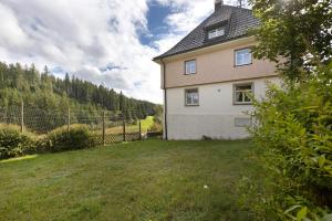 a house in a field next to a fence at Ferienheim Eisenbach in Eisenbach