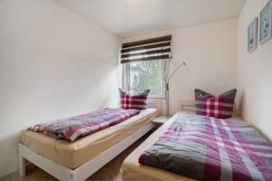 a bedroom with two beds and a window at Baumfuchs Ferienbungalow in Wesenberg
