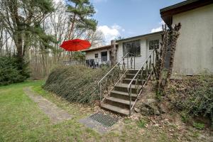 a house with a staircase and a red umbrella at Baumfuchs Ferienbungalow in Wesenberg