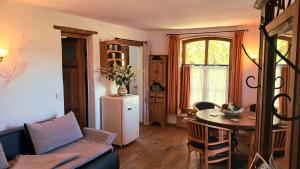a living room with a table and a refrigerator at Ferienwohnung Sophienhof in Loitz