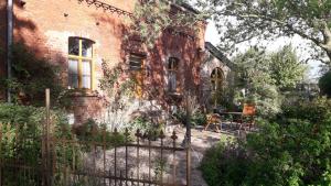 a brick house with a fence in front of it at Ferienwohnung Sophienhof in Loitz