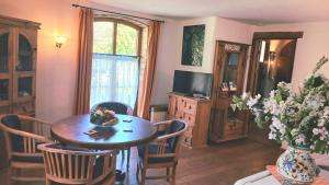 a living room with a table and chairs and a television at Ferienwohnung Sophienhof in Loitz