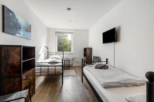 a bedroom with two beds and a tv on the wall at Key2Komfort in Duisburg