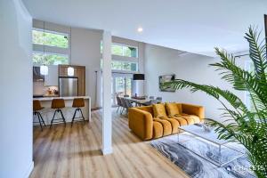 a living room with a yellow couch and a table at Villa Boreale - Private Spa Pool & Foosball in Valcartier Station