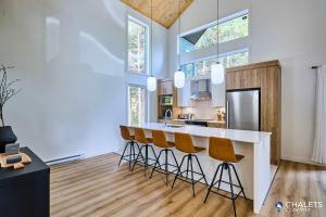 a kitchen with a counter and stools in a room at Villa Boreale - Private Spa Pool & Foosball in Valcartier Station