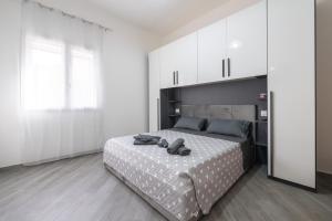 a bedroom with a large bed and white cabinets at Casa Claudia in Assemini