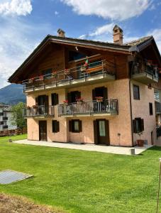 a large house with a balcony and a lawn at Maison Le Cré Appartamento 4 in Introd