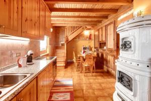 a large kitchen with wooden cabinets and a table at Dolce Casa vicino a Bormio in SantʼAntonio