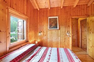 a bedroom with a bed in a wooden room at Dolce Casa vicino a Bormio in SantʼAntonio