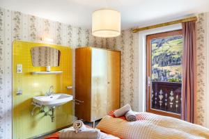 a bathroom with a sink and a bed and a mirror at A Nett’s Nest in Hainzenberg