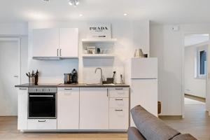 a kitchen with white cabinets and a couch at Schönes Apartment am Kaiserstuhl in Bahlingen
