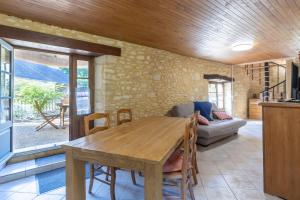 a kitchen and dining room with a wooden table at Moulin au coeur de la nature in Thonac