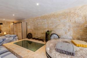 a room with a glass tub and a stone wall at Moulin au coeur de la nature in Thonac