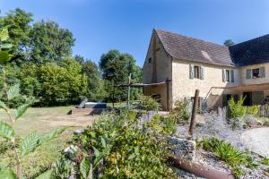 an old house with a garden in front of it at Moulin au coeur de la nature in Thonac