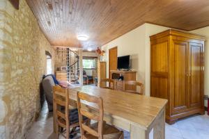 a dining room with a wooden table and chairs at Moulin au coeur de la nature in Thonac