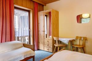 a bedroom with two beds and a window at Mittermüllerhof Feldthurns in Velturno