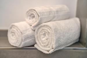 a pile of towels on a shelf in a bathroom at Gästehaus Heimelig in Herbolzheim +112 photos