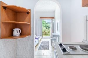 a kitchen with an archway leading to a patio at Maltas studios in Corfu +90 photos