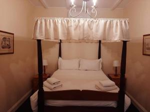 a bedroom with a four poster bed with a canopy at De Kothuize 7 in Graaff-Reinet