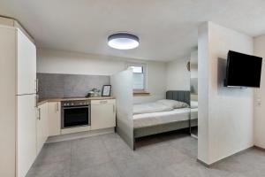 a small kitchen with a bed and a television at Kleine Auszeit in Rheinfelden +7 photos