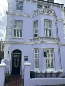 a white house with a black door at Gyves House in Eastbourne