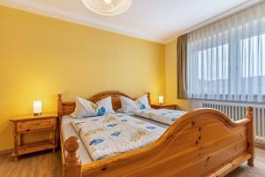 a bedroom with a wooden bed and a window at Ferienwohnung Berghansenhof in Wolfach