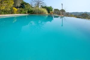 a large swimming pool with blue water at Appartement Numéro 2 - piscine in Valbonne