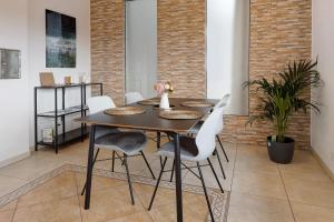 a dining room with a table and white chairs at Reif Markelfingen in Radolfzell am Bodensee