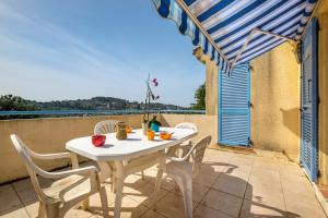 a white table and chairs on a balcony at Appartement Numéro 2 - piscine in Valbonne