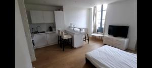 a white room with a bed and a desk and a kitchen at Logement entier rue Sainte Catherine in Bordeaux